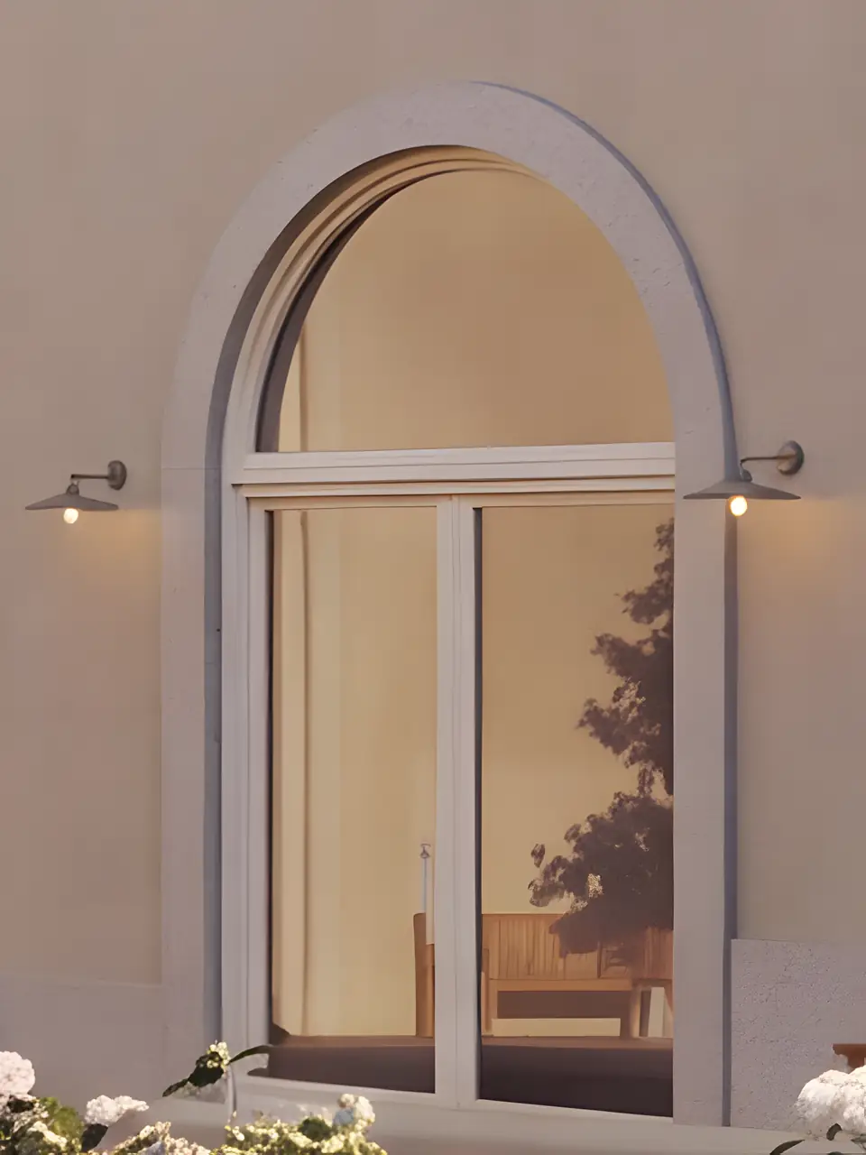 Visualisation of an arched glazed door in Cais's cream court facade, with a wall lamp on each side.