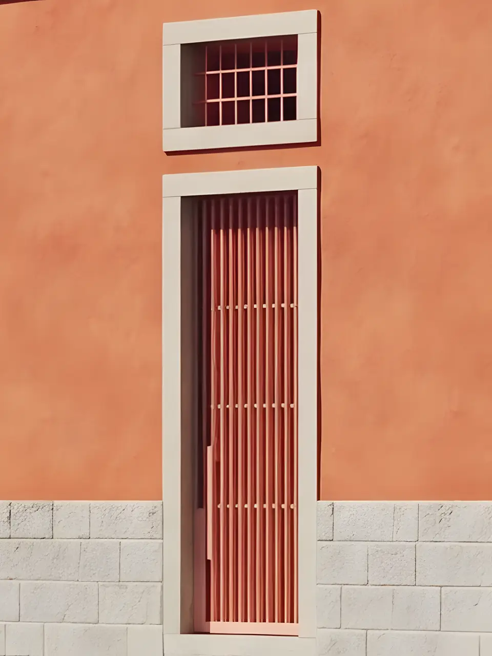 Visualisation of a tall barred door in Forno's terracotta street front, under a small barred window in a stone frame.