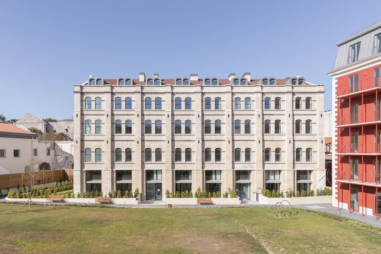 Ponte from the garden: a pale brick façade with rows of paired arched windows above the lawn.